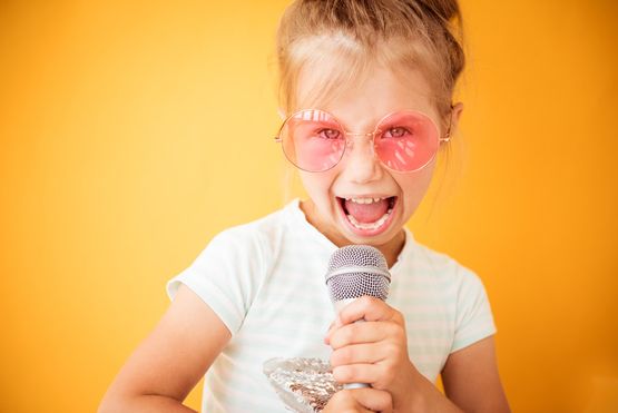 Kind singt mit Mikrofon