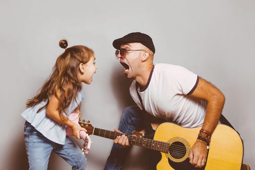 Vater und Kind spielen Gitarre